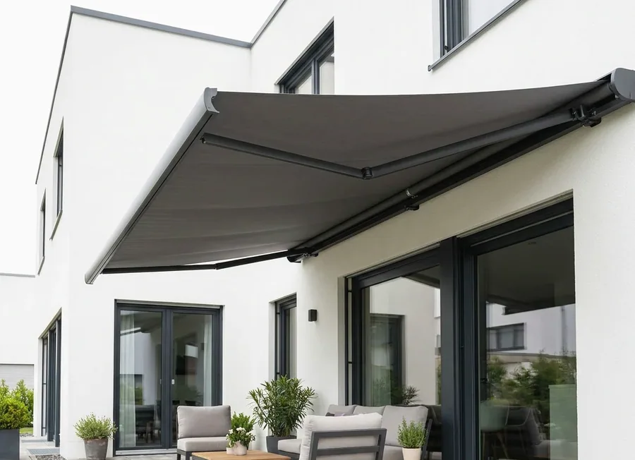 Folding-arm awning extended on hinged arms over a Blair Atholl patio, fabric canopy shading the seating with no posts in the way